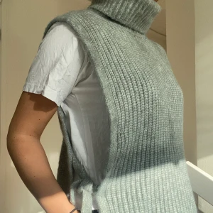 Stickad väst - Jättefin stickad väst från Lindex. Den har en hög krage och är öppen på sidorna med en rosett. Strl M, köparen står för frakten💕