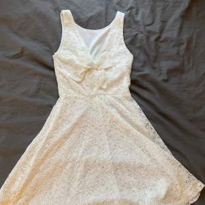 En vit klänning från Dennis Maglic med en rosett på ryggen❣️ Använd en gång och kommer inte till användning längre. Klänningen har dragkedja och vaddering. Köpare står för frakt, skriv för fler bilder!