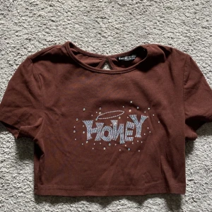 Brun kort och tajt t-shirt  - Säljer denna ”honey”crop top från Shein. Rekommenderar till någon som har en mindre byst på grund av att den är väldigt tajt.  köparen står för frakten❤️