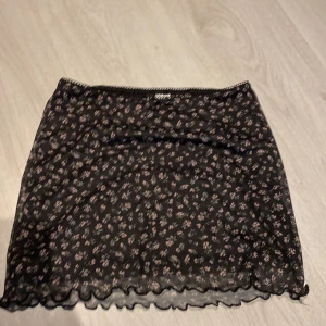 Mini skirt - En svart blommig mini skirt i storlek xxs oanvänd (köparen står för frakt)