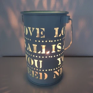 Ljuslykta i metall, sminkborsthållare, pennställ - Love is all you need - Ljuslykta i metall - vit utvändigt och blå invändigt. Kan såklart användas till annat också, t.ex. som pennställ. Love is all you need. 14 cm hög och 9 cm i diameter. 