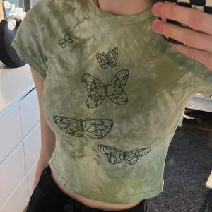 Jättegullig t-shirt med glittriga fjärilar som är i en mer croppad modell! Står storlek M men är väldigt tight så skulle uppskatta den mer som xs i storleken! Köpt från emmiol💚Frakt tillkommer!