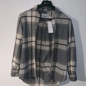 Jeremy check flannel strl S - grå flannel skjorta i märket ”les deux” köpt på pondus för två månader sedan för org priset 1300kr. Den är inte använd en ända gång pga att den inte passar mig, Skjortan är i topp skick