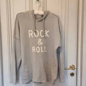 Rock och Roll tröja - Rock and Roll tröja med tryck. Grå hoodie som är alldrig andvänd. Välldigt Zadig och Voltair aktigt. Köpt i år från ett franskt/italienskt märke. Snygg i passformen. Säljer då den är för litten