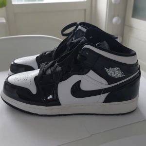 Air Jordan 1 Mid Carbon Fiber (GS) /NYTT PRIS - Svart/vita Jordans i mycket gott skick. Knappt ett år gamla och endast använda vid ett tillfälle. 
