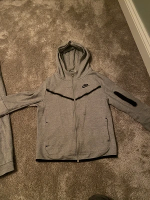 Grå Nike tech fleece  - Säljer min gråa Nike tech fleece bra skick o använd ett fåtal  gånger. Storlek XL barn på båda, inköpt för ungefär 1800 kr. Pris kan diskuteras vid snabb affär.