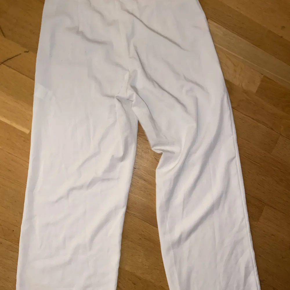 Vita kostymbyxor från Bikbok. Ganska genomskinliga, så man får ha hudfärgade trosor under så syns inget. . Jeans & Byxor.
