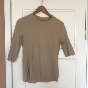 Beige tröja  - Från weekday. Modellen är klippt nedtill och i armarna. Halvlånga ärmar, brukar ha dem uppvikta. 