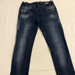 Mörkblåa låg midjade jeans med storlek W28. 