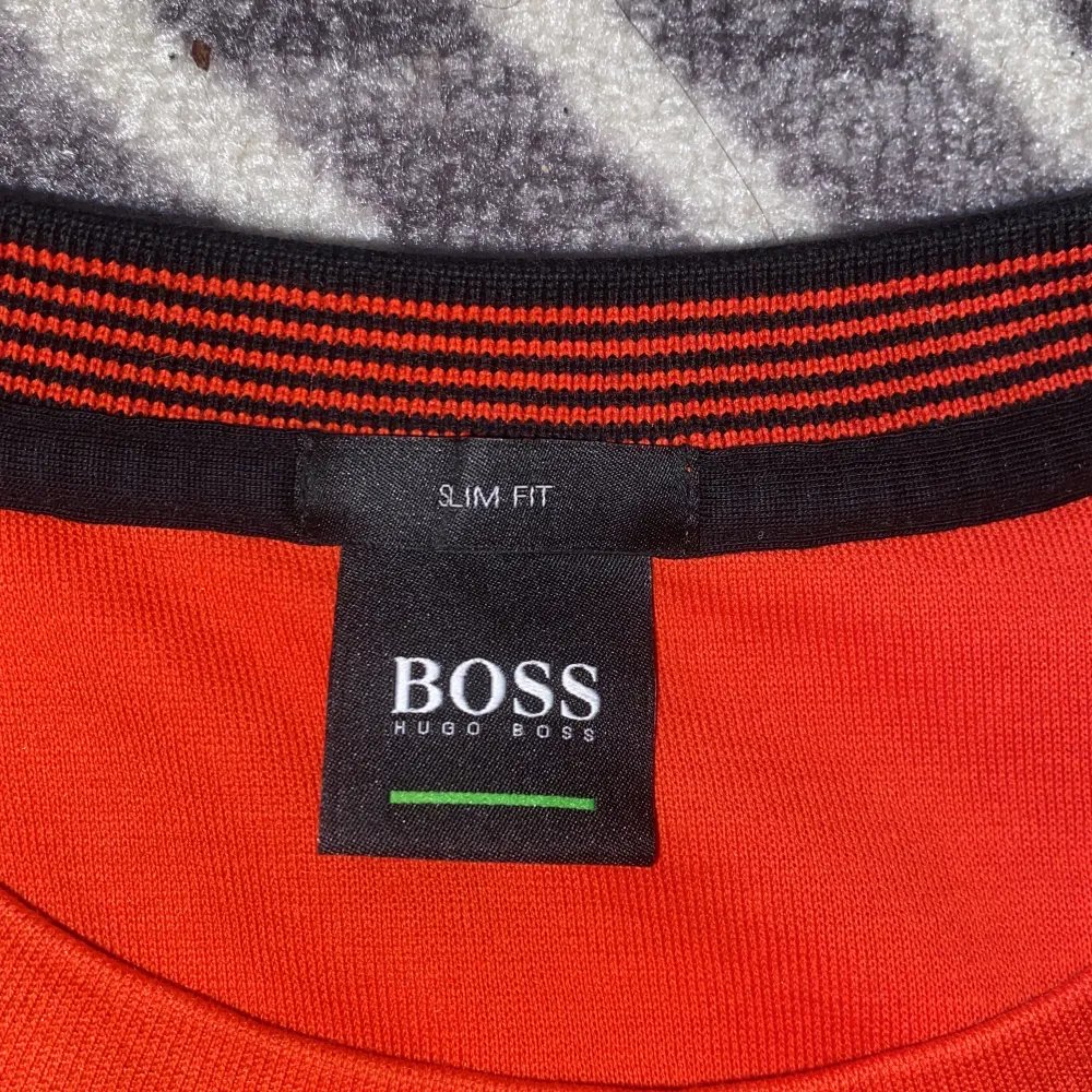En Röd/Orange Boss tröja i storlek L. Den är Slim Fit och för män men passar lika bra för kvinnor. Använd en gång. . Tröjor & Koftor.
