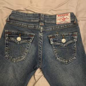 Super fina lågmidjade bootcut jeans från true religion. Sitter perfekt finns mindre slitningar längst ner. Köparen står för frakt. Det blir budgivning vid många intresserade🥰 midjemått: 38cm stretchiga. 78cm innerbenslängden  . är 156cm 