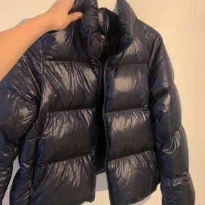 Jacka  - Intresse på min nyköpta jacka ifrån uniqlo. Helt oanvänd. Färgen är mörkblå i verkligheten och glansig som i sista bilden🥰Ny pris:1299kr. Ljusterbar i ryggen Möts gärna upp i Stockholm!  