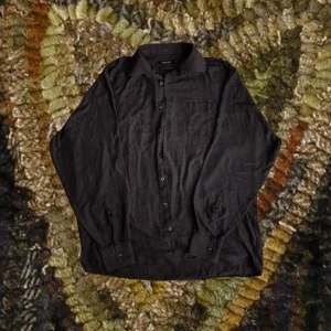 Mörkgrå skjorta  - Grå skjorta! Väldigt tunn och flowy, armarna sitter väldigt stora :) 