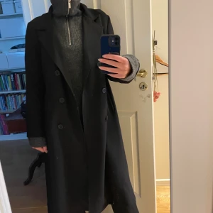 Trenchcoat - Trenchcoat i svart. Aldrig använd.