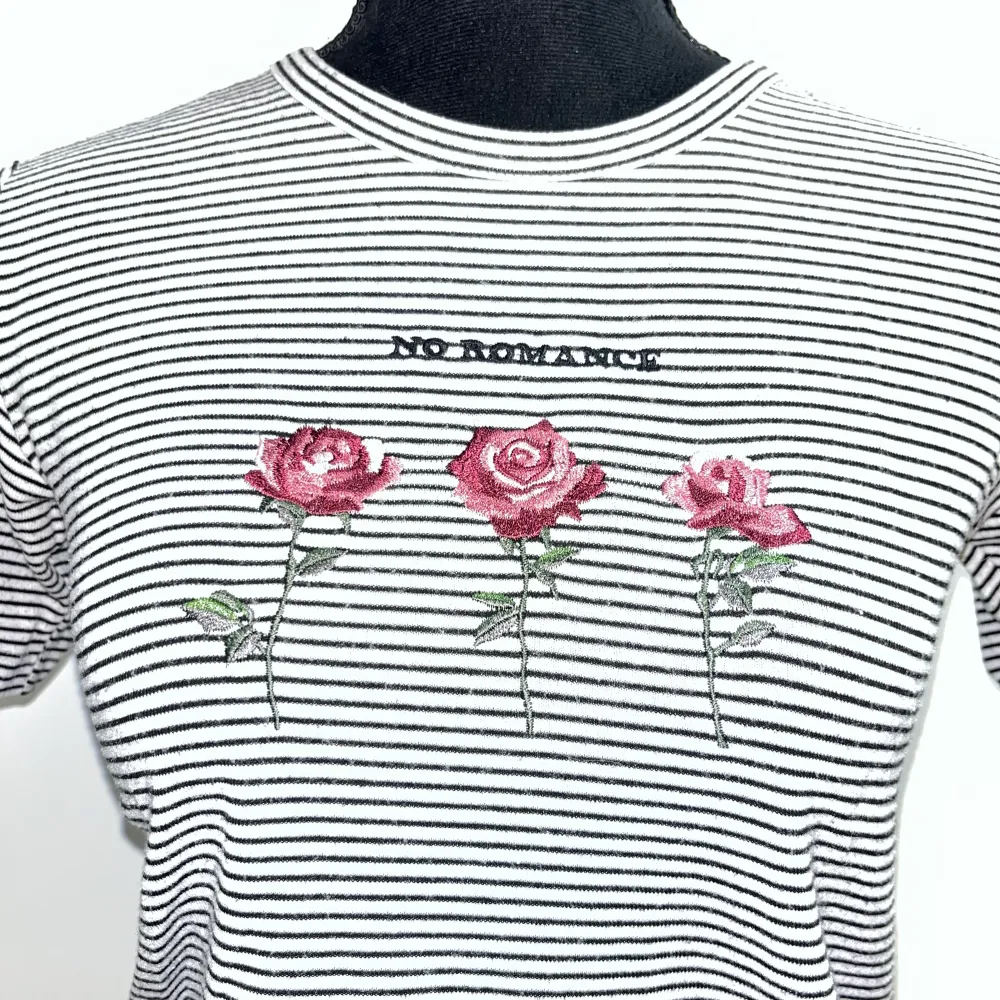 Vit-och svartrandig t-shirt från Topshop i storlek 36. Har broderi på framsidan med texten No Romance. T-shirts.