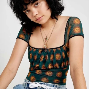 Urban Outfitters mesh grön croptopp  - Jättesnygg grön mesh croptopp från Urban Outfitters med solar som mönster, i bra skick!! 💚🌞köpt för över 3-4 år sedan och den är helt slutsåld på Ub!🥰🍀Storlek L men passar bra på både S och M!! 💚💚