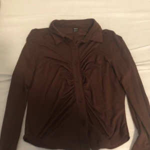Brun tröja - Säljer en brun tröja med knappar på då den inte kommer till användning. Använd bara en gång. Den är i storlek m men är liten i storlek så passar för nån som har storlek s.💕