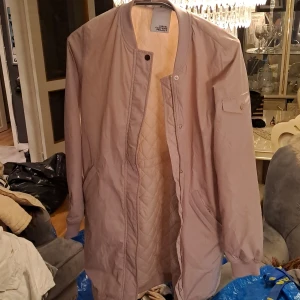 Vårjacka - Säljer en fin vårjacka i en kräm ljus rosa/beige färg, helt oanvänd så i helt ny skick och är köpt för 2000 kr. Är storlek xs men passar även S då den är lite större i passform