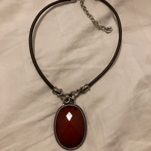 Vintage halsband - Vintage halsband med ett jätte stort hänge (5,5cm) och kedja i äkta läder. Det är svårt att se i bilderna men läder kedjan är en superfin mörkbrun färg!  Skriv gärna om ni har frågor. 