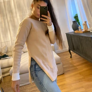 Rosa tjock tröja. - Tungt material, ganska tjock med öppen rygg och öppningar på båda sidorna. Köpt på asos.