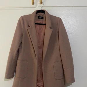 Rosa kappa i strl S - Rosa kappa i storlek S kan passa i M i vissa fall. Kommer lite under rumpan och den är över knäna.