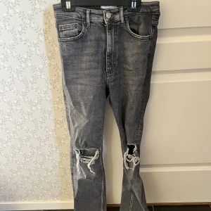 Gråa jeans  - Gråa jeans med hål i knäna från zara, även en slits nere vid foten💕 fint skick
