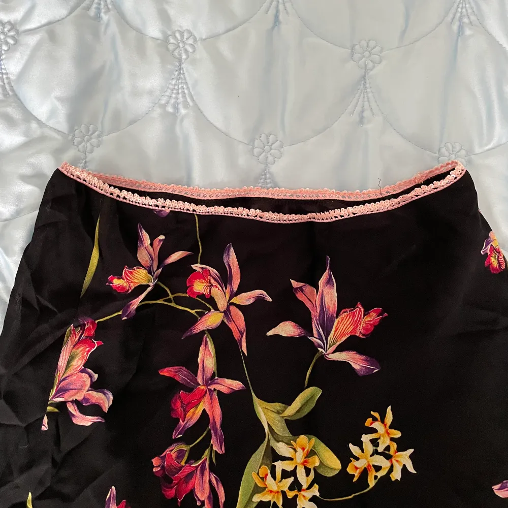 Svart midikjol med en stretchig rosa paljettrad i midjan 🌸🪷🌼 Inbyggd underkjol! Älskar det blommiga mönstret, så somrig och tropisk! 🪸. Kjolar.