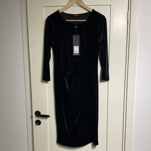 Ilse Jacobsen klänning - Svart skön sammetsklänning i tight modell. Med krus fram vid ena sidan.  Oanvänd med prislapp kvar! Stl S