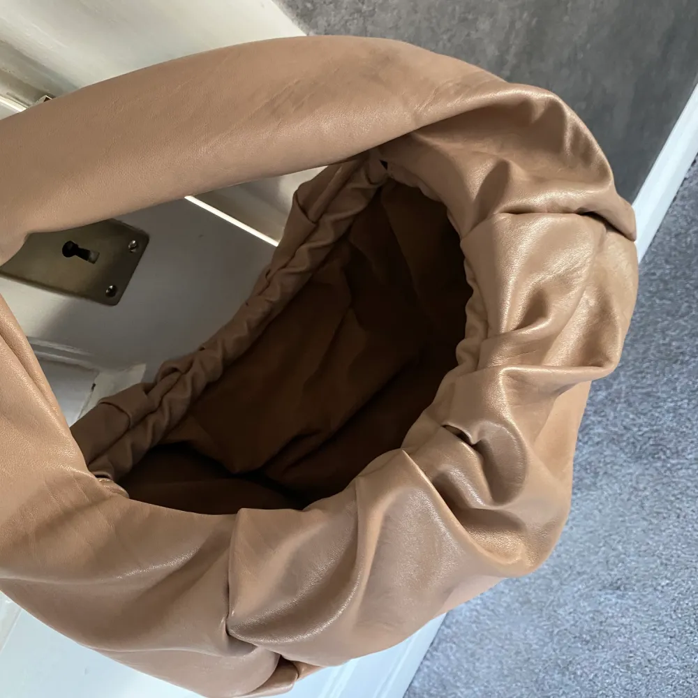 Helt ny beige Axel väska i pösig modell mått ca 35x25. Accessoarer.