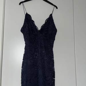 Mörkblå klänning i spets i storlek xs, köp från nelly.com. Använd 2-3 gånger! På vissa ställen har spetsen nopprat sig lite men detta är inget som syns! Färgen syns bäst på bild 3!