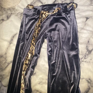 Byxor - Byxor som är utsvängda längst ner och  ett liopard band och det är bara 1 ficka där bak på rumpan