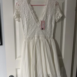 Studentklänning - Vit klänning köpt för studenten. Aldrig använd, endast provad. Prislapp sitter kvar 