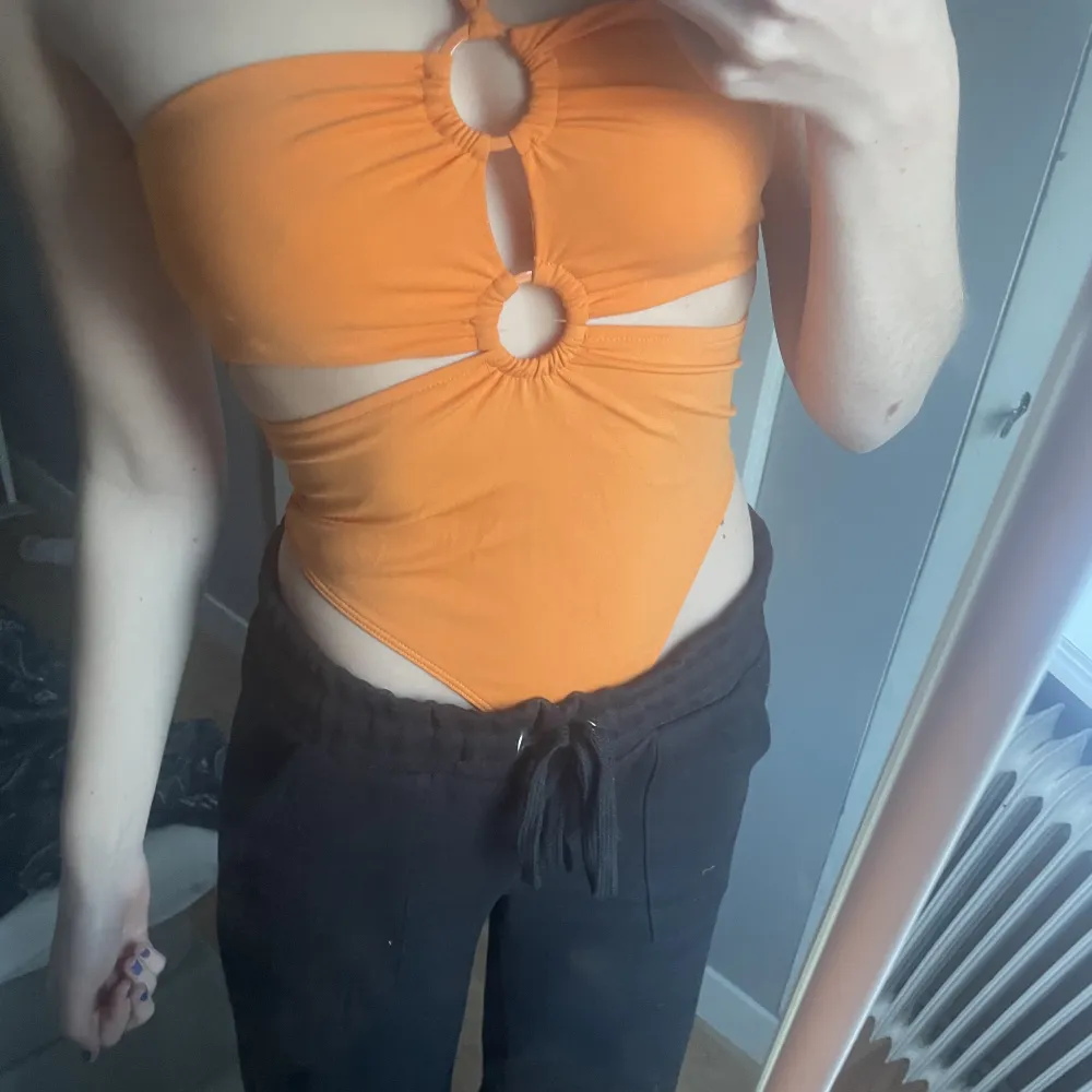 Helt oanvänd orange body från Zara. Med snöre runt halsen och fina detaljer vid bröstkorgen . Toppar.