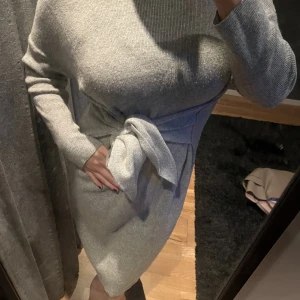 Massimo Dutti stickad klänning - Stickad klänning från Massimo Dutti!  Grå färg, så skön och passar till vinter, höst och vår, samt sommar kvällar!  Den är inte så tajt utan man knyter den själv via bandet runt midjan, därför passar den många storlekar och kroppsformer!  