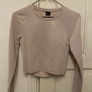 Tröja från Gina Tricot - En beige basic tröja från Gina Tricot i storlek M. Den har en en öppning på ryggen som gör hela tröjan. Har endast använt den två gånger. 