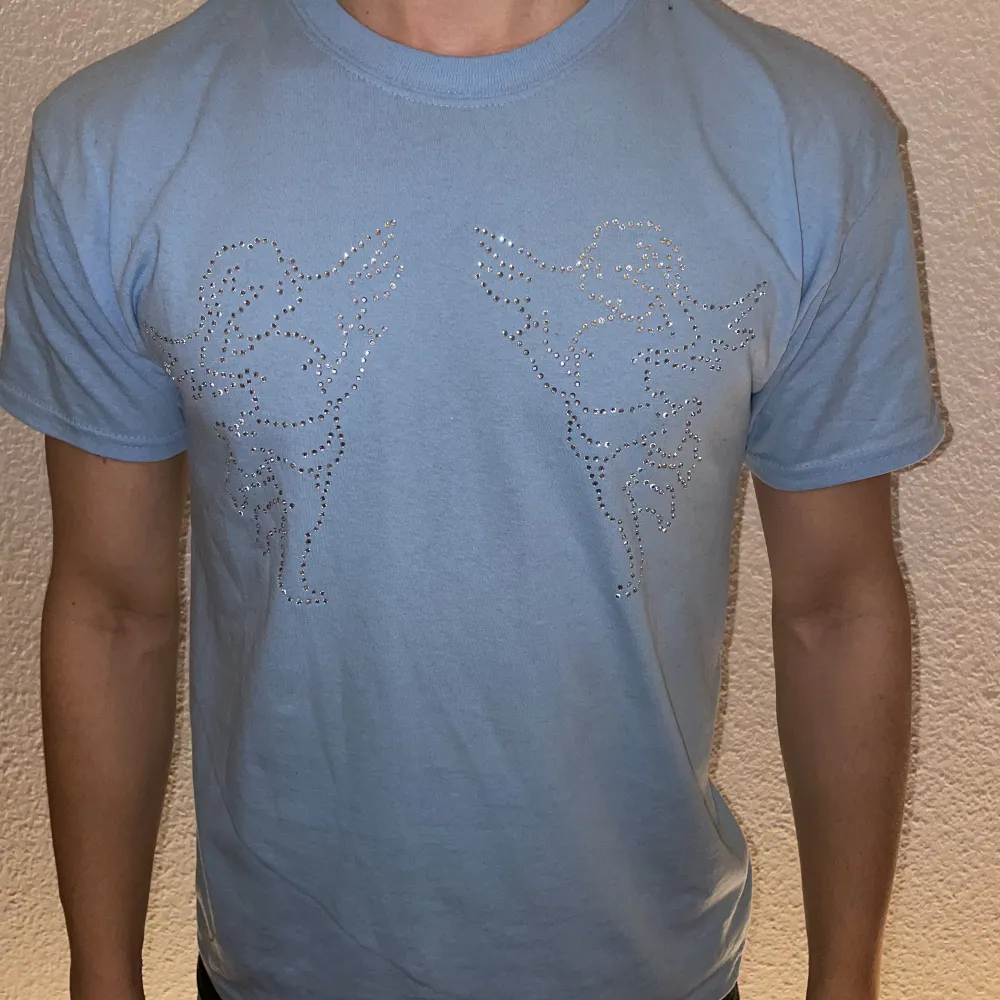 Ljusblå T-shirt designat med rhinestone. T-shirts.