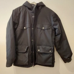 Svart Fjällräven jacka  - Svart Fjällräven jacka i storlek XS i bra skick! Den är fodrad på insidan så den håller en varm och den har 4 stora fickor på framsidan.  