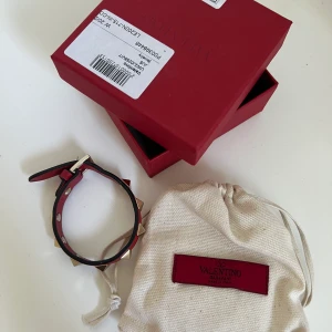 Rött valentinoarmband - Säljer mitt fina valentinoarmband. Köpt för ca 1 år sedan men sparsamt använt så har inga defekter. Superfint skick! Kan mötas upp i Göteborgsområdet eller frakta! Isåfall står köparen för frakt!