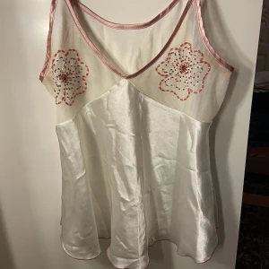 Vit topp - Vit topp med rosa pärl detaljer över brösten, även mesh över brösten 