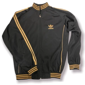 Adidas Hoodie  - Svart och guld Adidas vintage hoodie. Använd få gånger, skick 8/10. Passar bäst på Medium och Small. Buda eller köp direkt för 300 + frakt‼️ Nypris 700kr. 
