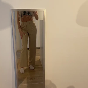 Nakd kostymbyxor  - Helt oanvända kostymbyxor i beige från nakd. I storlek 36. Har även slits på baksidan. 