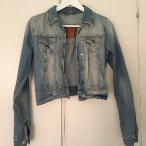 Blå jeansjacka med slitningar från Gina Tricot. Två bröstfickor. Storlek XS