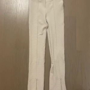 Beiga KostymByxor - Riktigt stiliga kostymbyxor i strl xs från HM. Skönt material och slitsade nertill samt bootcut. Helt oanvända.