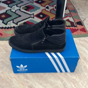 Svarta mocka skor - Svarta mocka skor med dragkedjor på sidan. Märket heter baldi london. I bra skick. I