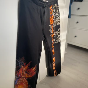 Svarta Joggingbyxor  - Ett par supermysiga joggingbyxor med ett galet häftigt tryck (drake). Jättesköna att ha på sig en kall eftermiddag. Frakten ingår även här i priset!