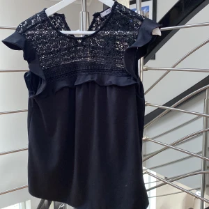 Svart topp med spets o volang - Cool topp med spets utan ärmar och med volang 