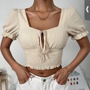 Beige söt topp - Söt toppens mycket fina detaljer.  Köparen står för frakt. 