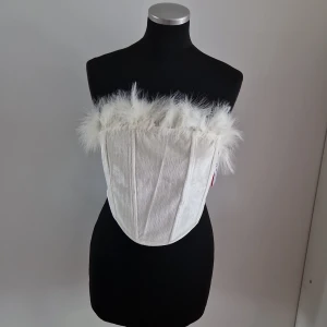 Cider tubetop - Alldrig använd, stor i storleken, creme vit tubetop med fjädrar, från cider.