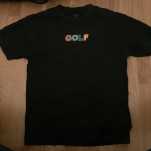 Svart golf t-shirt! - En svart GOLF tröja i storlek L. Texten är lite sliten men de är inget man tänker på. Säljer på grund av att den inte kommer till användning. 