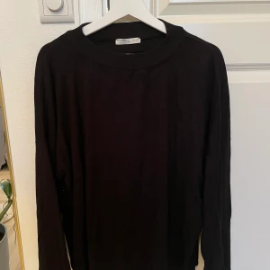 Svart stickad tröja  - Svart finstickad tröja från Pull&Bear. Inte alls använd många gånger! Ärmarna är rätt vida och går ner över händerna. Storlek XS men sitter lite oversized på mig som annars har S/M i tröjor. Köparen står för frakt, kan annars mötas upp i Stockholm.
